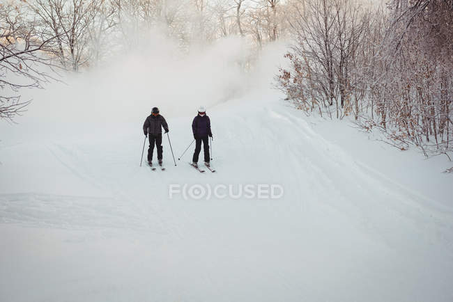 Deux skieurs skient dans les Alpes enneigées en hiver — Photo de stock