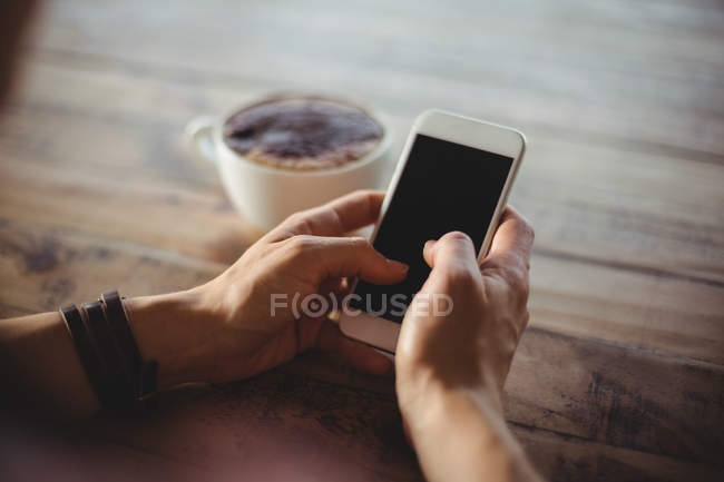 Mujer usando el teléfono móvil en la cafetería - foto de stock