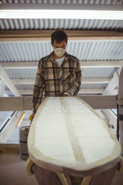 Uomo che fa tavola da surf in laboratorio interno — Foto stock