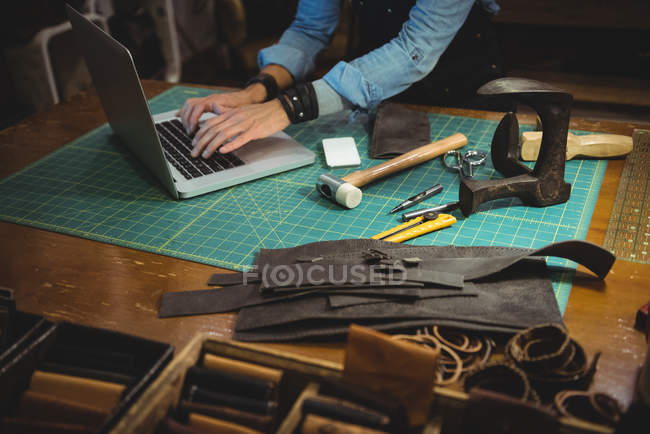Milieu de section de l'artisan en utilisant un ordinateur portable dans l'atelier — Photo de stock