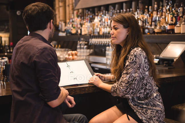 Пара обговорює меню за барною стійкою — стокове фото