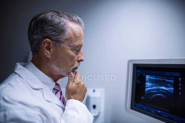 Cirurgião olhando para a máquina de dispositivo ultra-sônico no hospital — Fotografia de Stock
