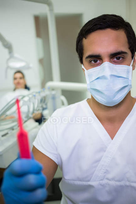 Portrait of dentist holding dental tools in dental clinic — Stock Photo