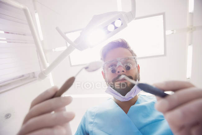 Close-up de dentista segurando ferramentas dentárias na clínica odontológica — Fotografia de Stock