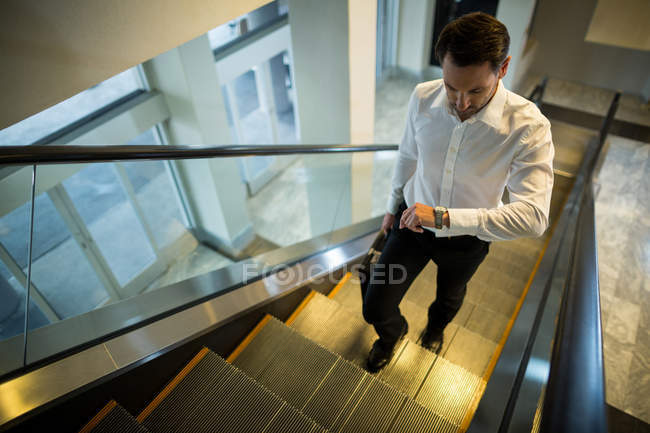 Pendler sucht Zeit beim Gehen auf Rolltreppe im Flughafen — Stockfoto