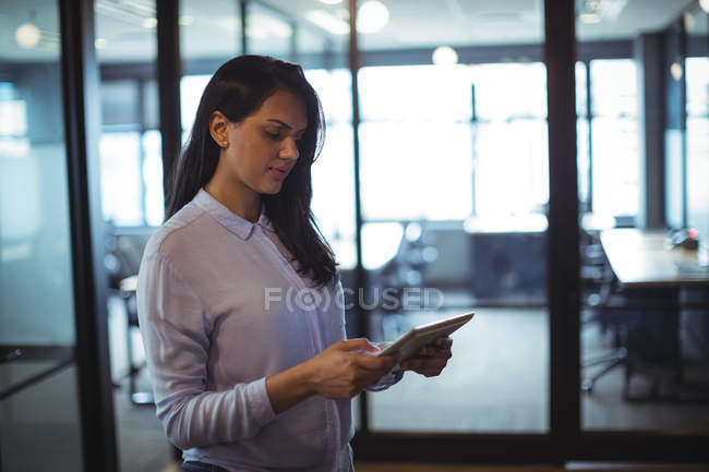 Бизнесвумен, использующая цифровой планшет в офисе — стоковое фото