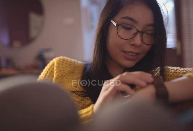 Mulher bonita usando relógio inteligente em casa — Fotografia de Stock