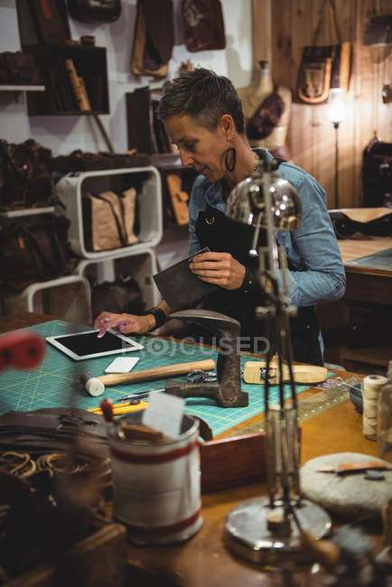 Mature craftswoman using digital tablet in workshop — Stock Photo