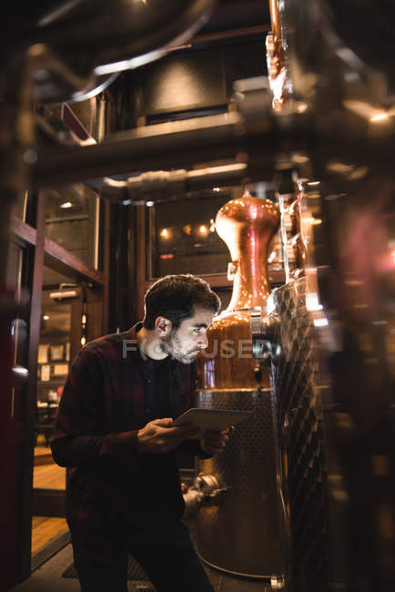 Hombre usando tableta digital en fábrica de cerveza - foto de stock