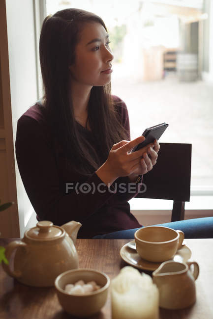 Bella donna che utilizza il telefono cellulare in caffè — Foto stock