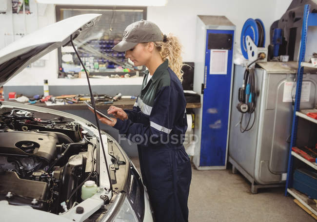 Механик-женщина с цифровым планшетом в ремонтной мастерской — стоковое фото