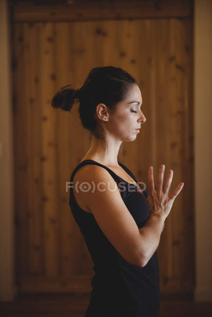 Woman practicing yoga in fitness studio, side view — Stock Photo