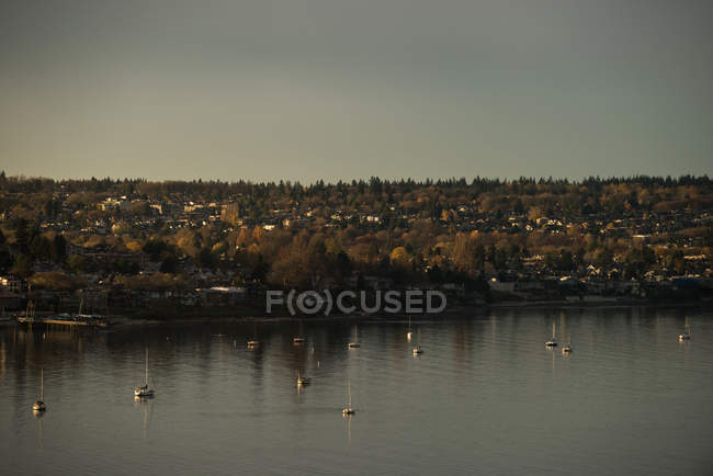 Vista panorámica de la ciudad y el lago durante el atardecer - foto de stock