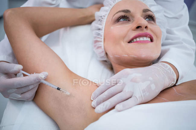 Nahaufnahme von Arzt, der Frau in ihre Armmulden injiziert — Stockfoto