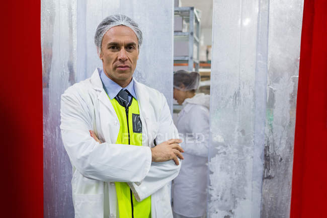 Retrato de técnico de pé com os braços cruzados na fábrica de carne — Fotografia de Stock