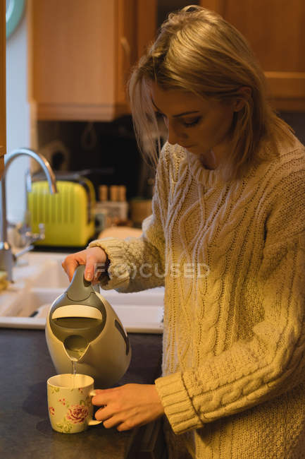 Женщина готовит кофе на кухне дома — стоковое фото