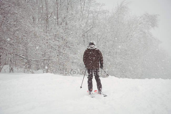 Mann fährt in Skigebiet den Berg hinunter — Stockfoto