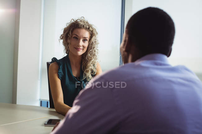 Empresaria y hombre de negocios interactuando entre sí en el cargo - foto de stock