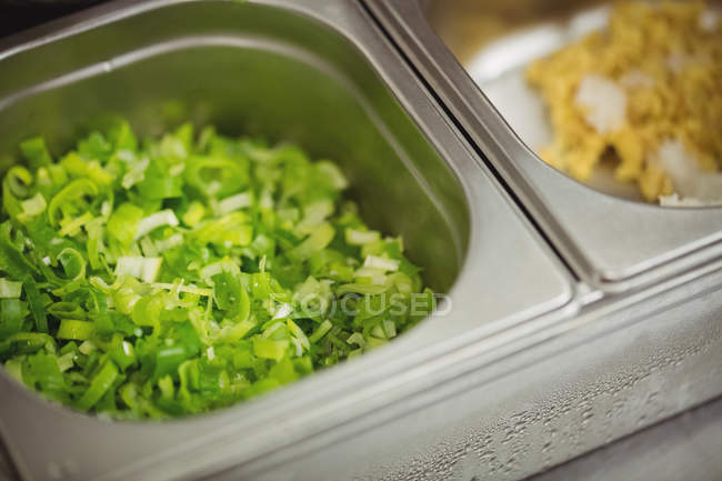 Primo piano di verdure a foglia tritate in contenitore nel ristorante — Foto stock