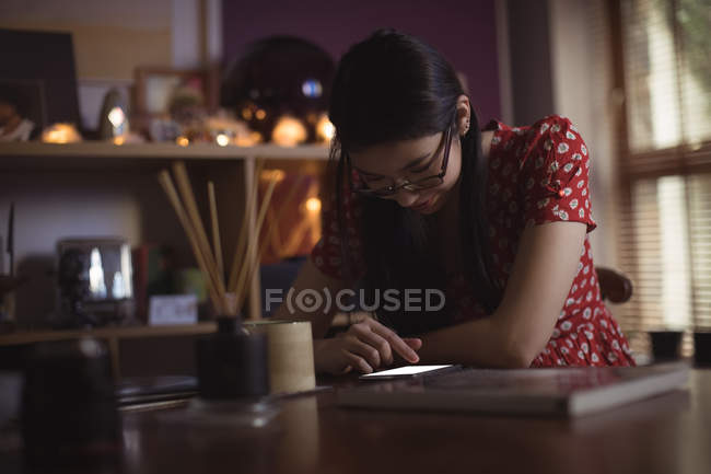 Woman using mobile phone on table at home — Stock Photo
