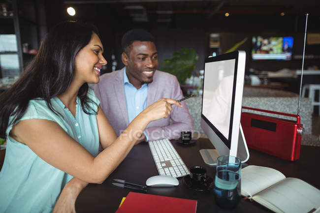 Бізнесмен і колега обговорюють комп'ютер в офісі — стокове фото