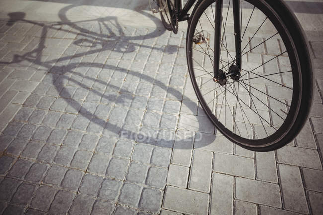 Vélo penché par balustrade de promenade à la lumière du soleil — Photo de stock