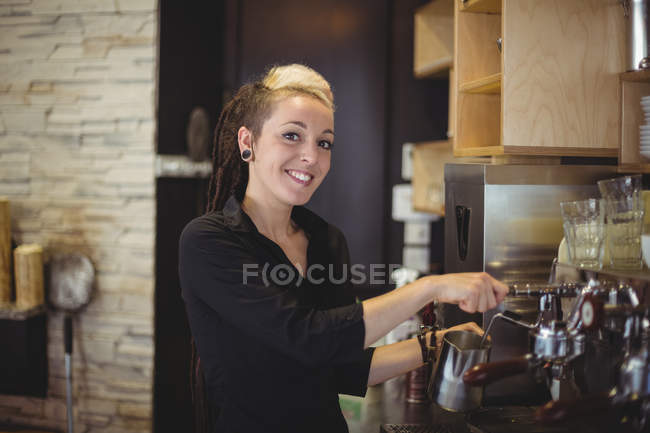 Retrato de la camarera usando la máquina de café en la cafetería - foto de stock