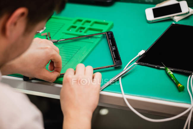 Close-up of man repairing digital tablet in repair center — Stock Photo
