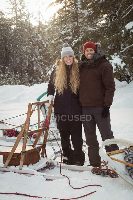 Musher stehen neben Schlitten in einer verschneiten Landschaft — Stockfoto