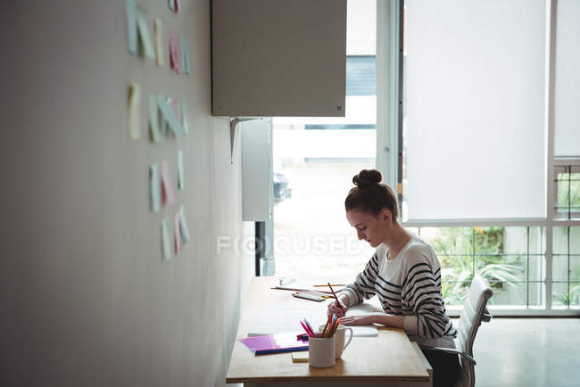 Business executive looking at blueprint in office — Stock Photo