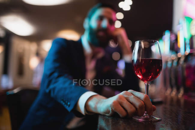 Бізнесмен тримає келих вина в барі — стокове фото