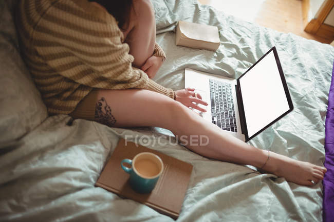 Mulher usando laptop na cama em casa — Fotografia de Stock