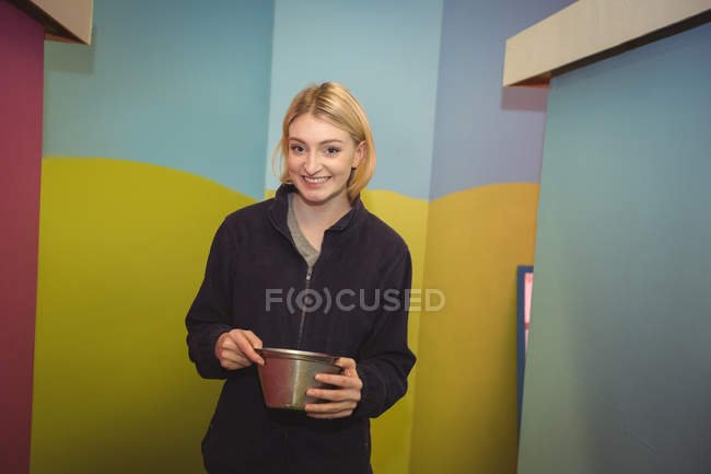 Portrait of woman carrying a dog bowl at dog care center — Stock Photo