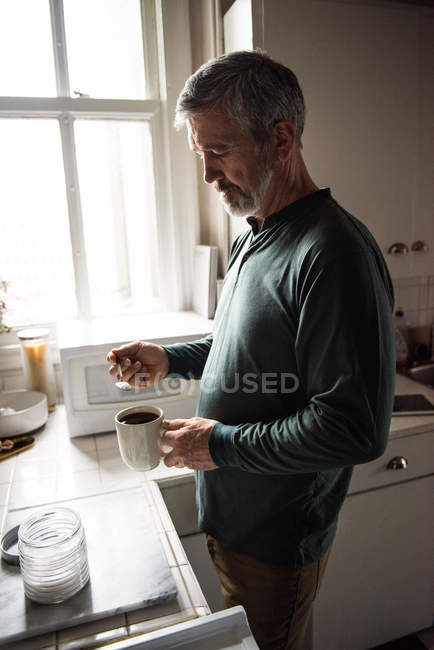 Чоловік готує чорну каву на кухні вдома — стокове фото