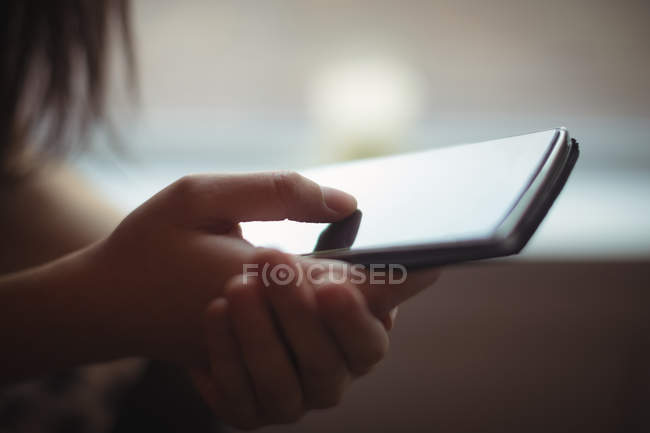 Mid section of woman using a mobile phone in cafe — Stock Photo