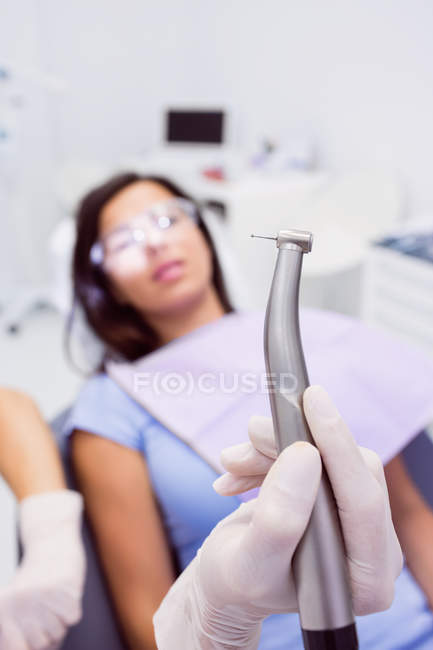 Close-up de dentista segurando peça de mão dentária na clínica odontológica — Fotografia de Stock