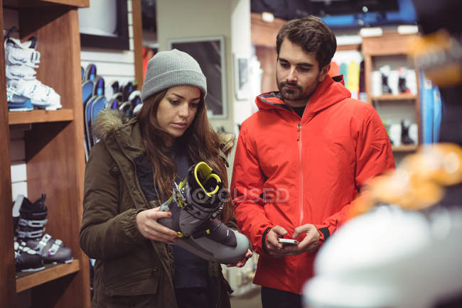 Pareja seleccionando zapato juntos en una tienda - foto de stock