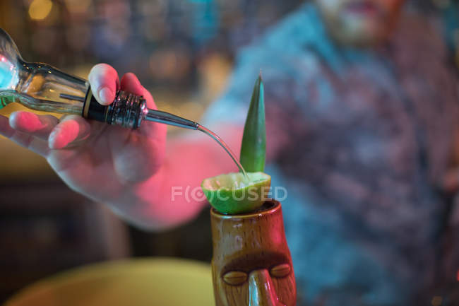 Barman preparando uma bebida no balcão no bar — Fotografia de Stock