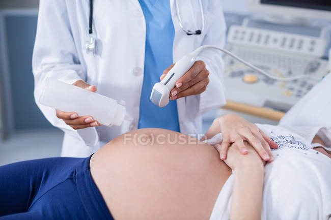 Pregnant woman receiving a ultrasound scan on the stomach in hospital — Stock Photo