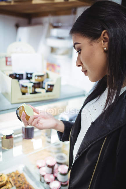 Woman selecting honey at food counter in supermarket — Stock Photo