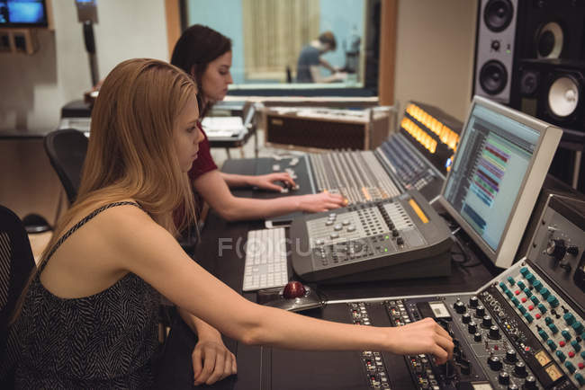 Engenheiros de áudio usando misturador de som no estúdio de gravação — Fotografia de Stock