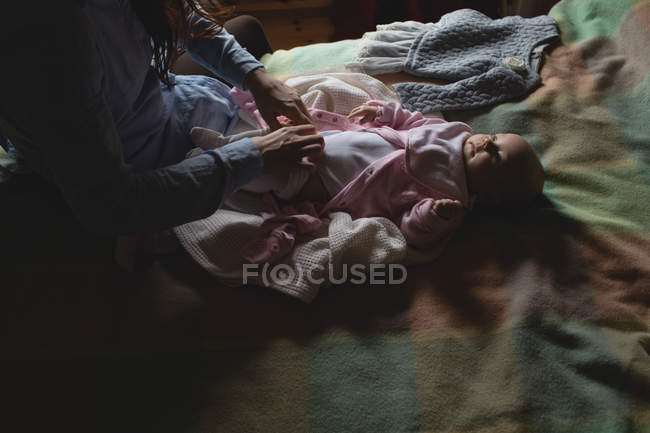 Mother changing baby diaper in bedroom at home — Stock Photo