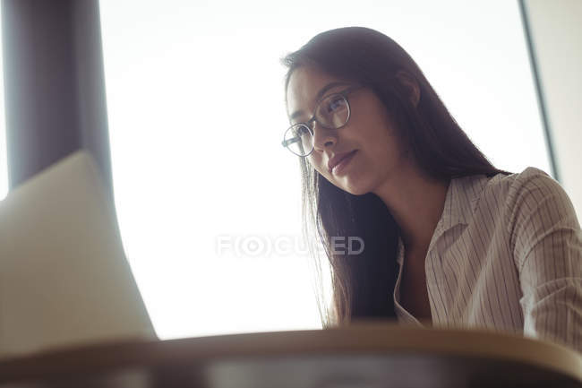 Businesswoman working on laptop in office — Stock Photo