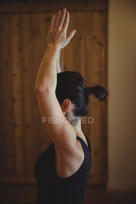 Женщина практикующая йогу в фитнес-студии, вид сбоку — стоковое фото