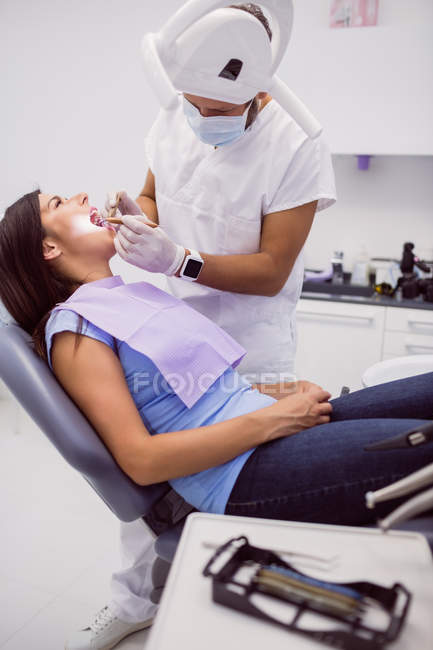 Dentist examining female patient teeth in clinic — Stock Photo