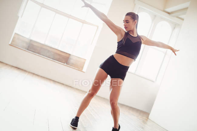 Jolie femme pratiquant la danse hip hop en studio — Photo de stock