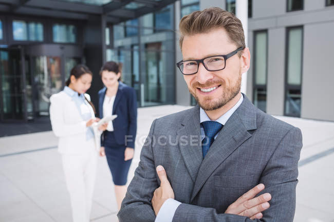 Portrait of a confidence businessman with arms crossed smiling — Stock Photo
