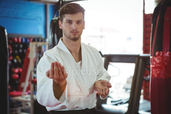 Ritratto di giocatore di karate che esegue una posizione di karate in palestra — Foto stock