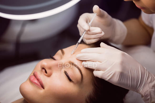 Giovane paziente di sesso femminile che riceve un'iniezione cosmetica sul viso in clinica estetica — Foto stock