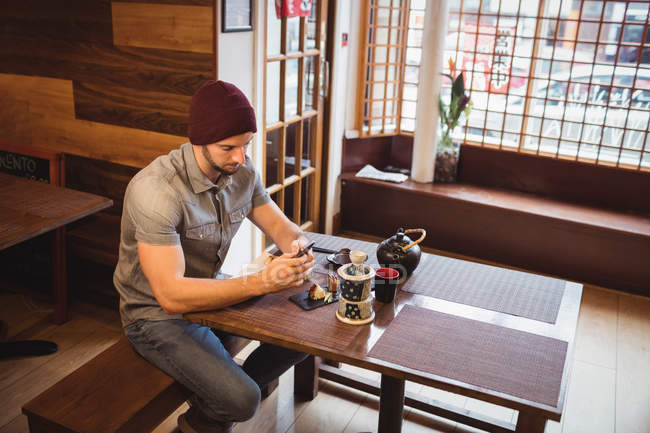 Mann benutzt Handy in japanischem Restaurant — Stockfoto